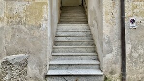 A stone staircase leading to an arched doorway, with a 'passo carrabile' sign indicating no vehicle access. - A Room de Scugnizzi (Naples)