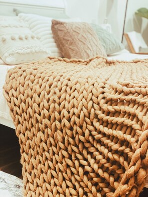 A bed with a knitted throw blanket and pillows. - A Nordic Design Apartment,close to the center, well prepared&super friendly host (Thành phố Đà Lạt)