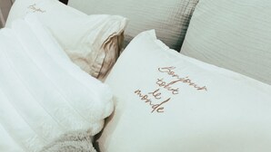 A bed with a fluffy grey blanket and pillows with embroidered text. - A Nordic Design Apartment,close to the center, well prepared&super friendly host (Thành phố Đà Lạt)