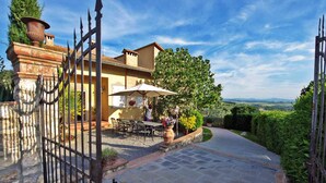 A gated patio area with outdoor seating and a view of the countryside. - Villa a Montaione ID 3114 (Iano)