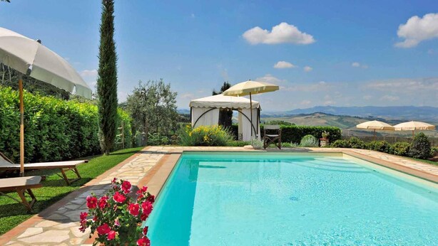 A swimming pool with a view of the countryside, surrounded by greenery and a gazebo. - Villa a Montaione ID 3114 (Iano)