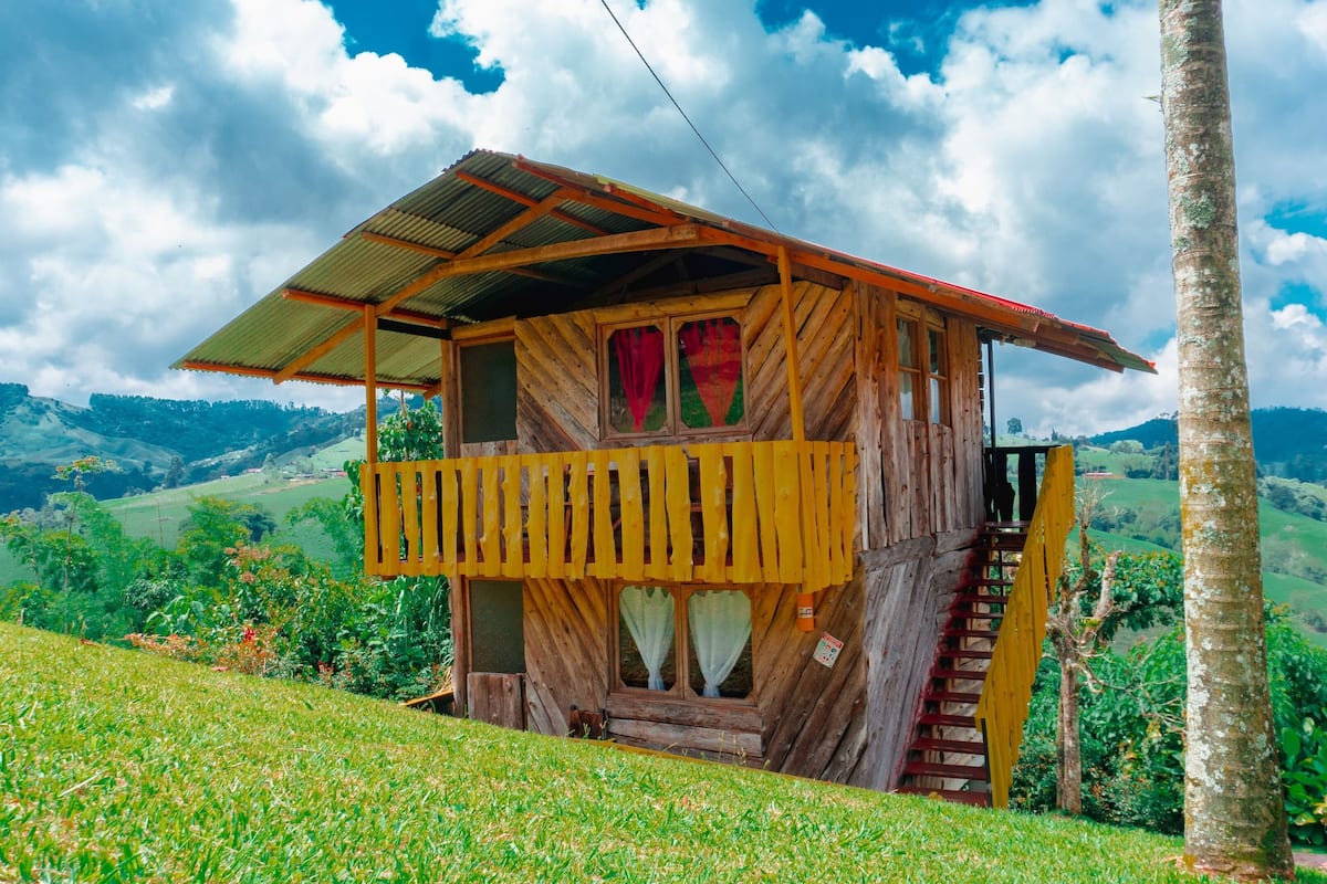 Eine Holzhütte mit Balkon, vor einer Bergkulisse gelegen.