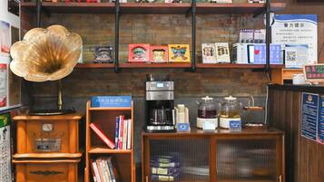 A coffee shop with a vintage gramophone, coffee machines, and shelves with books and tea boxes.