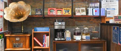 A coffee shop with a vintage gramophone, coffee machines, and shelves with books and tea boxes.
