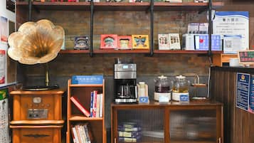 A coffee shop with a vintage gramophone, coffee machines, and shelves with books and tea boxes.