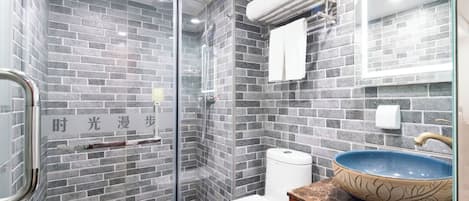 Un bagno moderno con box doccia in vetro, un WC bianco e un lavandino in ceramica blu.