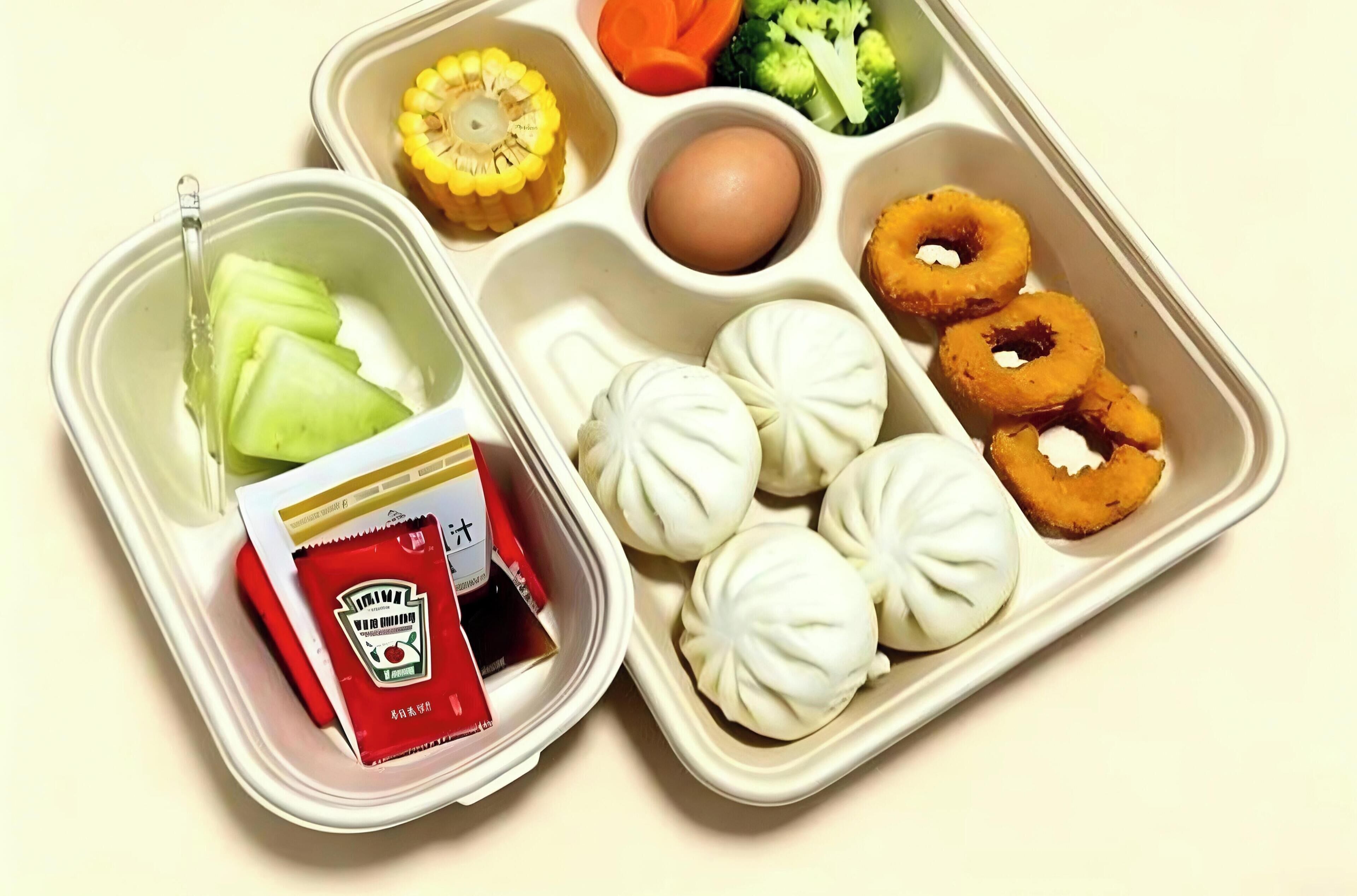 Una bandeja de comida con diferentes alimentos, como verduras, un huevo duro y albóndigas.