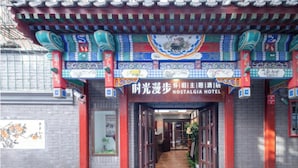 La entrada del Hotel Nostalgia con elementos arquitectónicos chinos tradicionales y un cartel en chino e inglés.