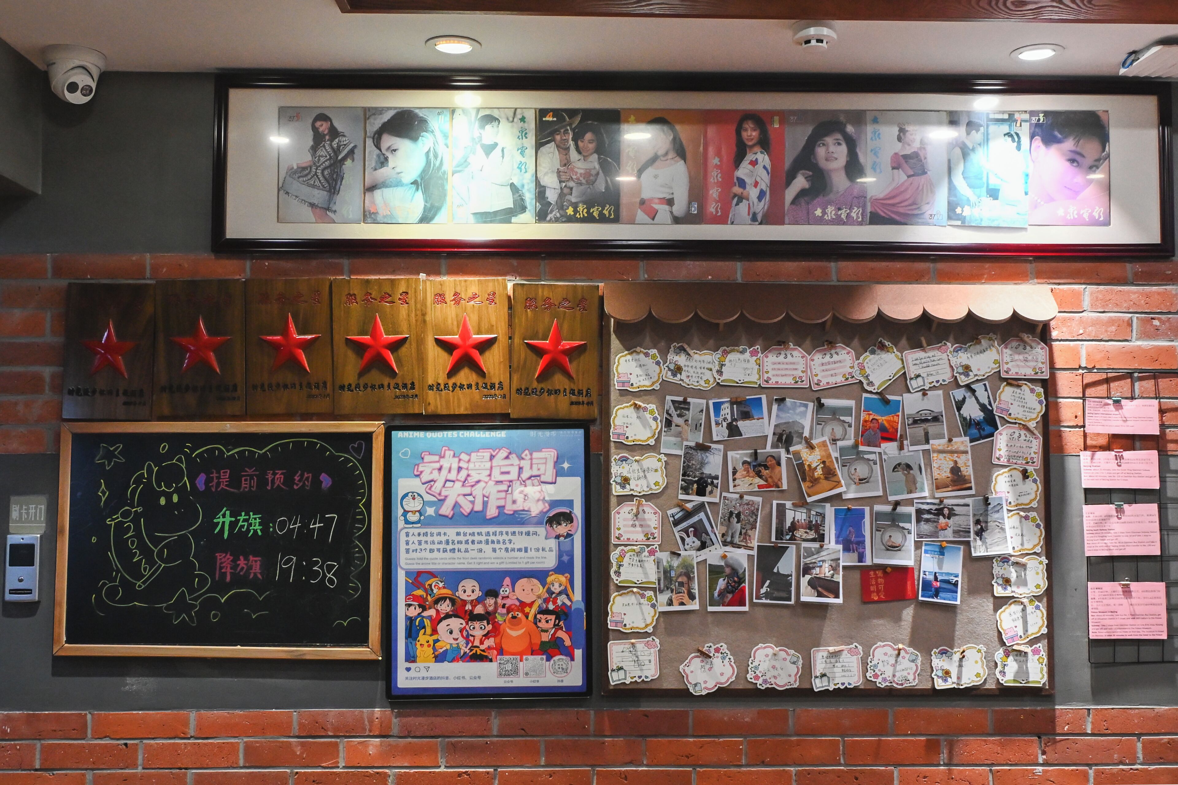 A wall with framed pictures, a bulletin board with photos and notes, and a chalkboard with writing.