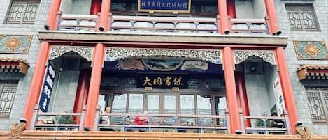 Un edificio tradicional de varios pisos con detalles arquitectónicos ornamentales, incluyendo una entrada destacada con un letrero.