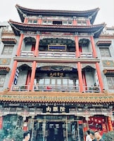 A traditional multi-story building with ornate architectural details, including a prominent entrance with a sign.