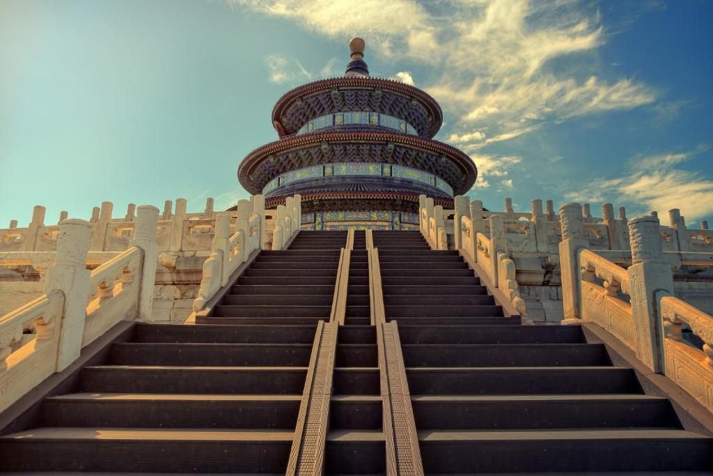 A grand staircase leading to a traditional Chinese pavilion with ornate railings and a clear sky above.
