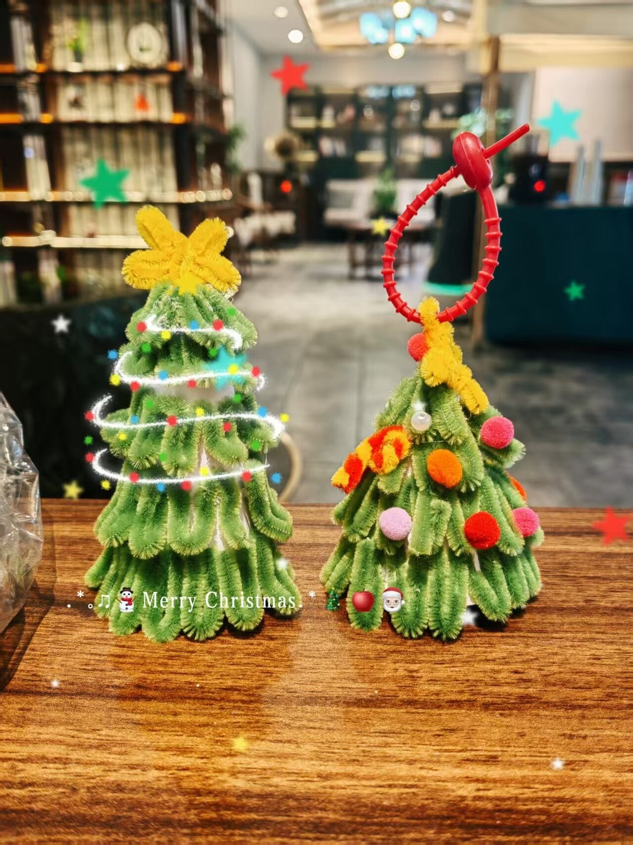 Dos árboles de Navidad con luces y adornos sobre una mesa de madera.