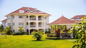 A multi-story hotel with a central courtyard, balconies, and a covered gazebo. - EN CASA @ Richmond Estate (Priory)