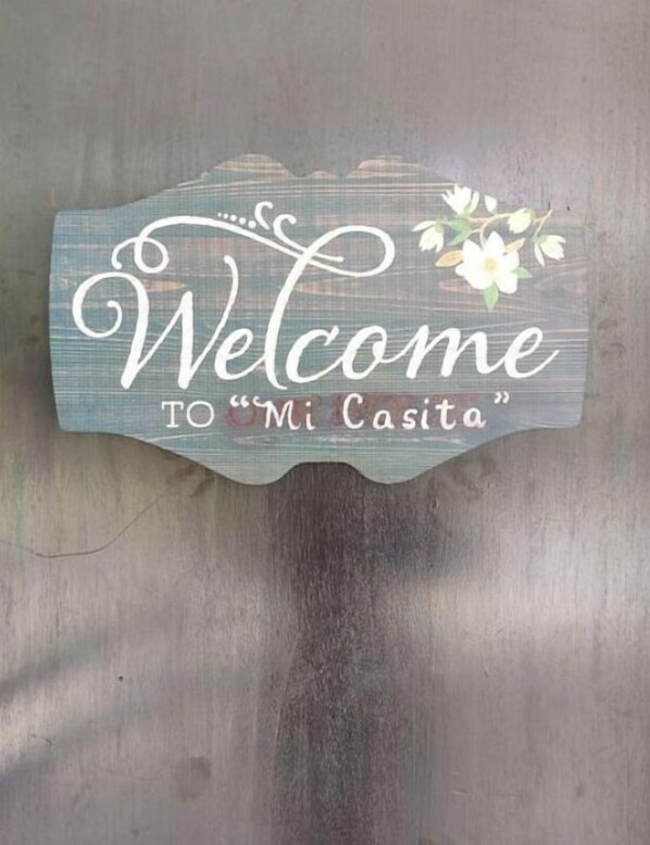 En träskylt med texten: ”Välkommen till ’Mi Casita’”.