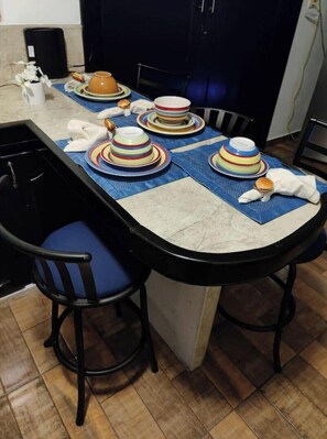 Cozy kitchen area with a dining table for two, featuring a stove, oven, and ample counter space.