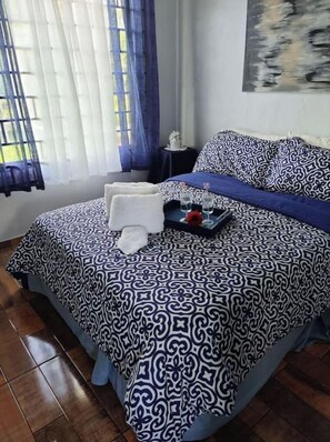 Cozy retreat with a large bed, bedside table, and a beautiful painting on the wall.