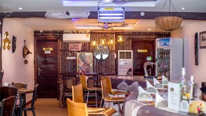 A restaurant with wooden furniture, a bar area, and a kitchen sign. - ADESHIE FIE HOTEL (Tarkwa)