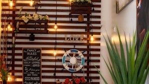 A modern interior with a wooden slat wall, string lights, a life preserver decoration, and a potted plant. - ADESHIE FIE HOTEL (Tarkwa)