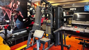 A gym with various exercise equipment, including a bench press, squat rack, and treadmill. - ADESHIE FIE HOTEL (Tarkwa)