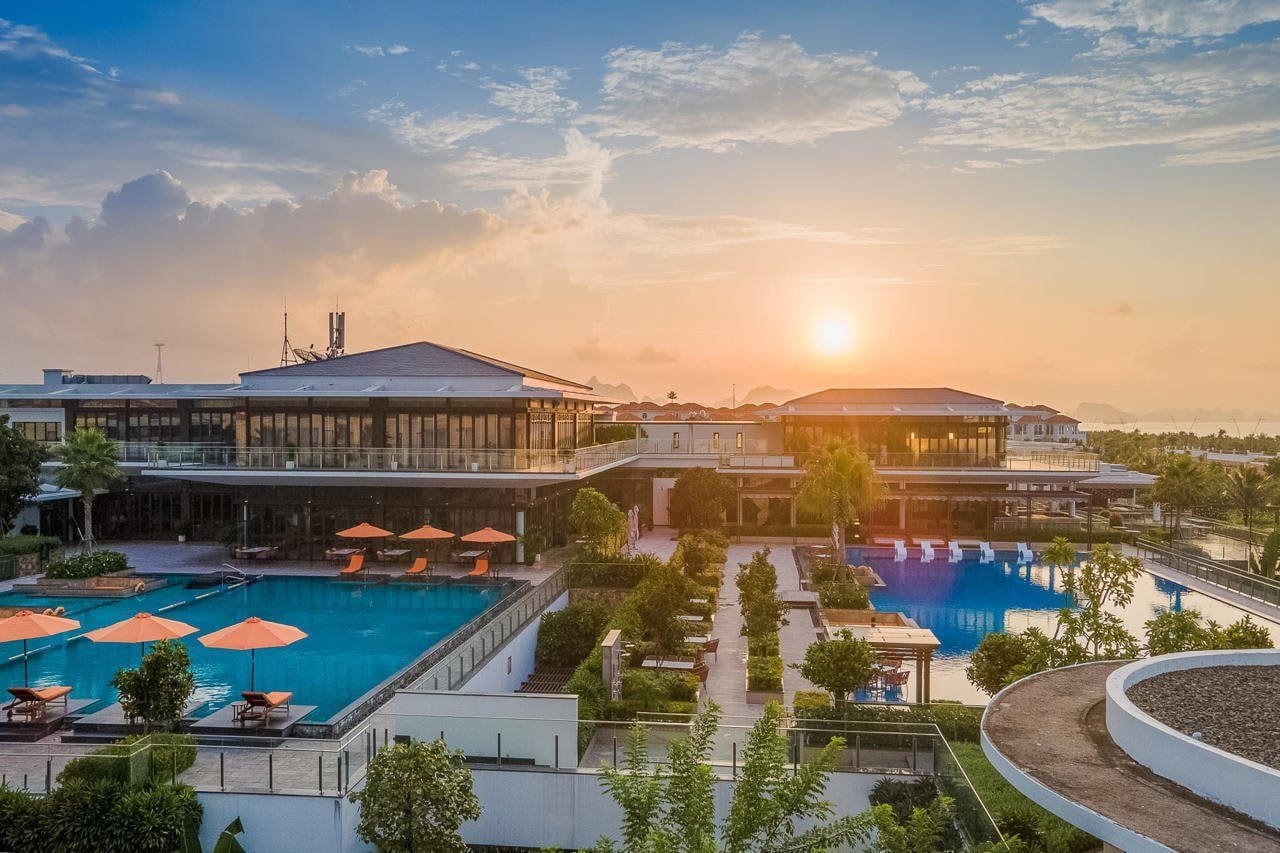 Un hôtel doté d’une piscine, d’un espace extérieur aménagé et offrant une vue sur le coucher de soleil.