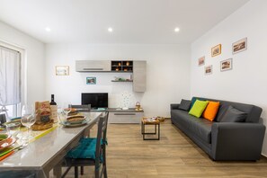 A modern living space with a dining area, kitchen, and seating area.
