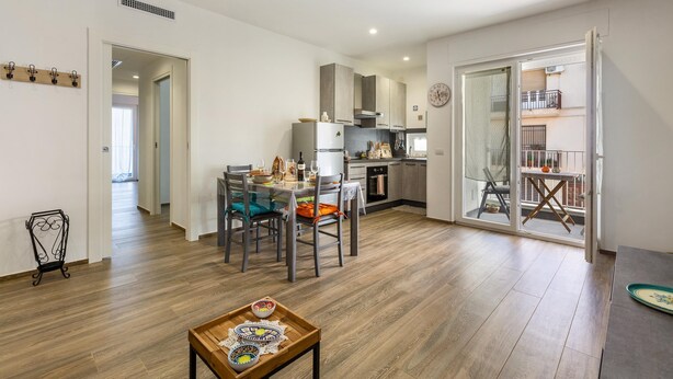 Un apartamento moderno con comedor, cocina y balcón.