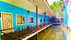 A blue building with a covered walkway over water. - Capital O 91017 Tuba Beach Resort @ Pulau Tuba (Pulau Tuba)