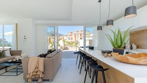Una cocina moderna con barra, ventanas amplias y vistas a la ciudad.