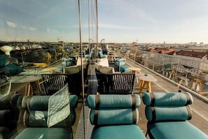 Una terrazza sul tetto con posti a sedere e tavoli, con vista sulla città.