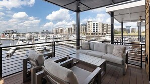 Een balkon met uitzicht op een jachthaven en gebouwen.