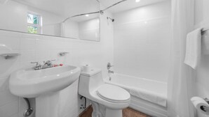 A modern bathroom with a sink, toilet, and shower.