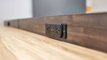 A close-up of a wall socket on a wooden surface.