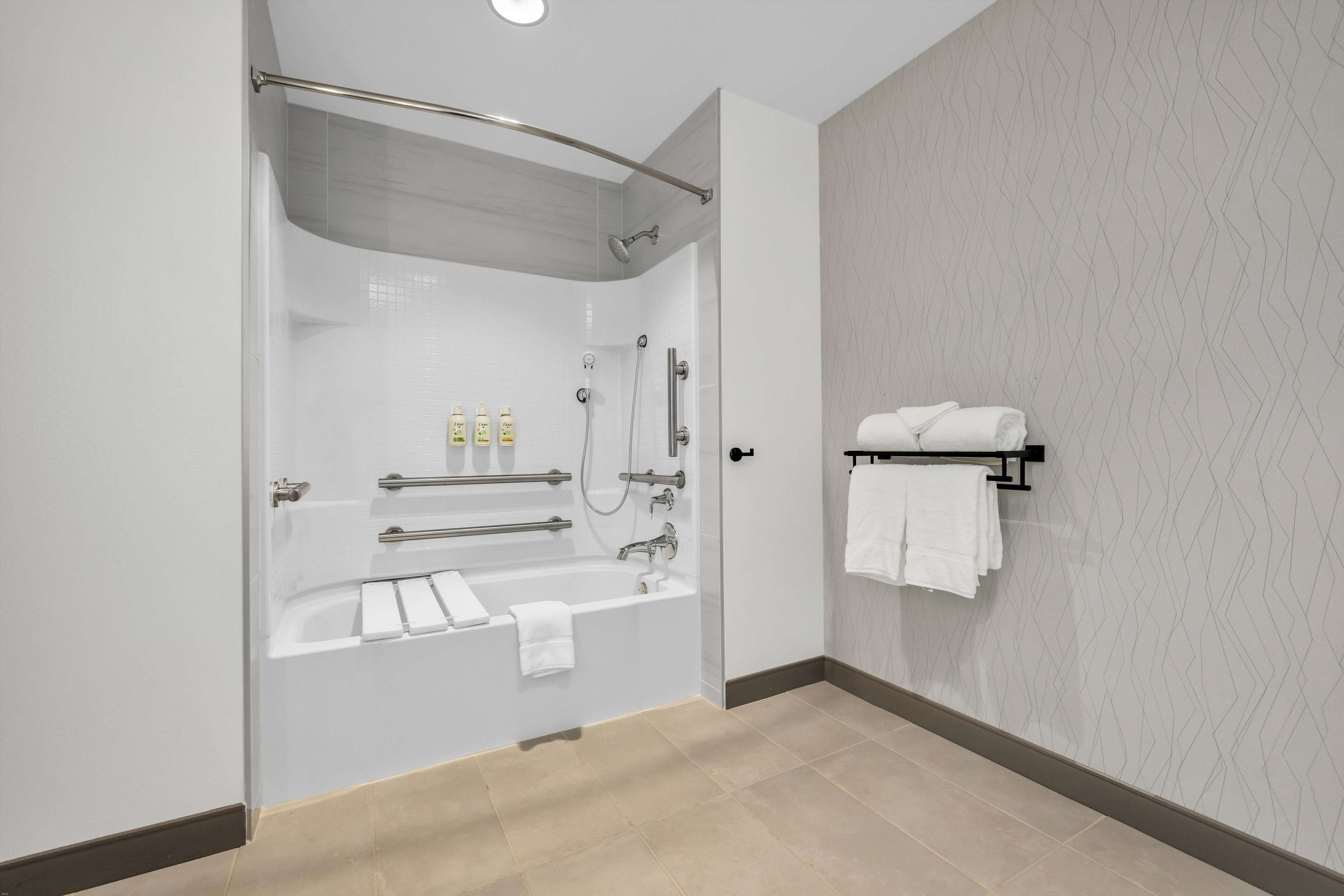 A modern bathroom with a glass-enclosed shower, a bathtub, and a towel rack.