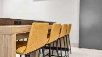 A conference table with four chairs, a wooden finish, and black legs.