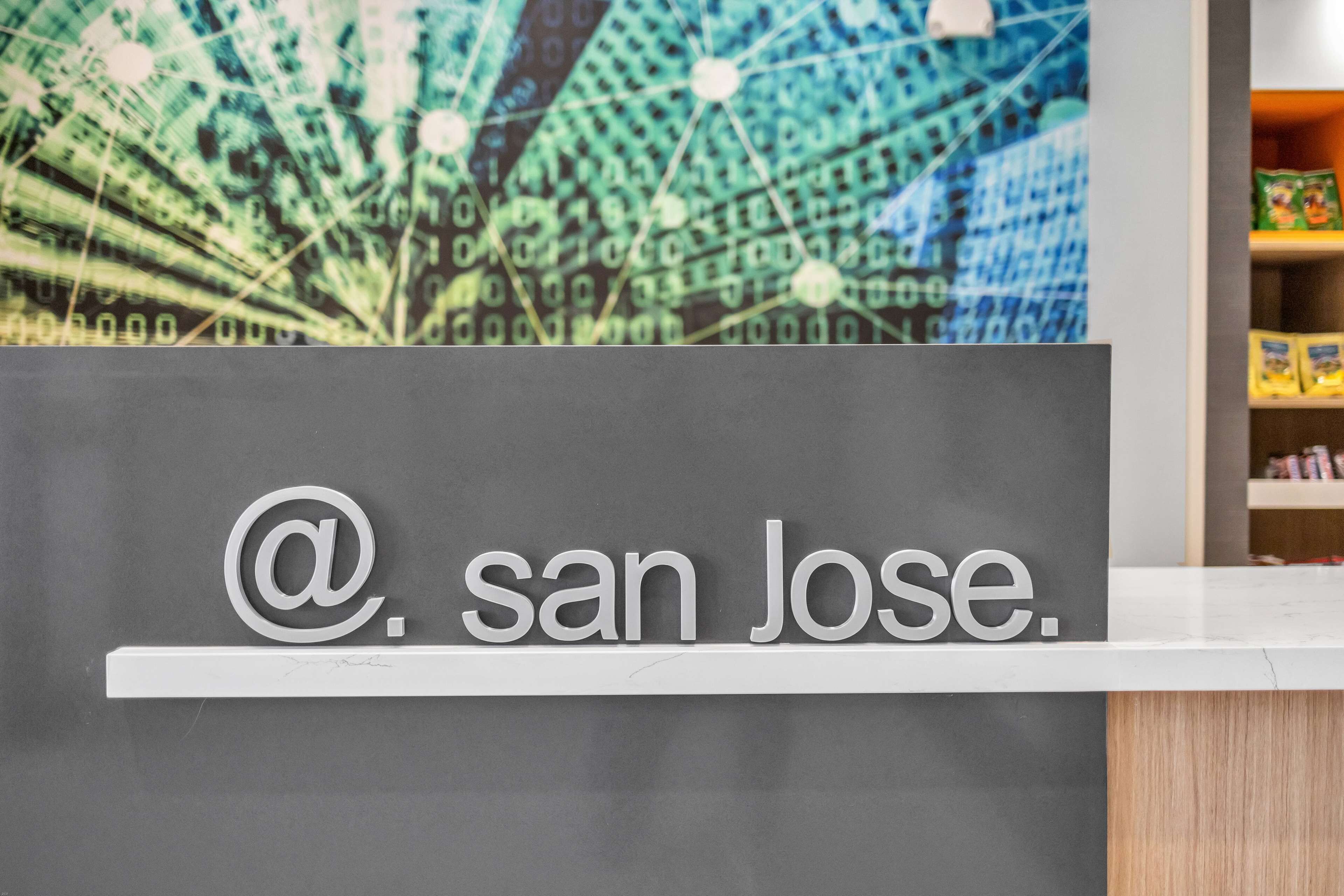 A reception desk with a digital display in the background.