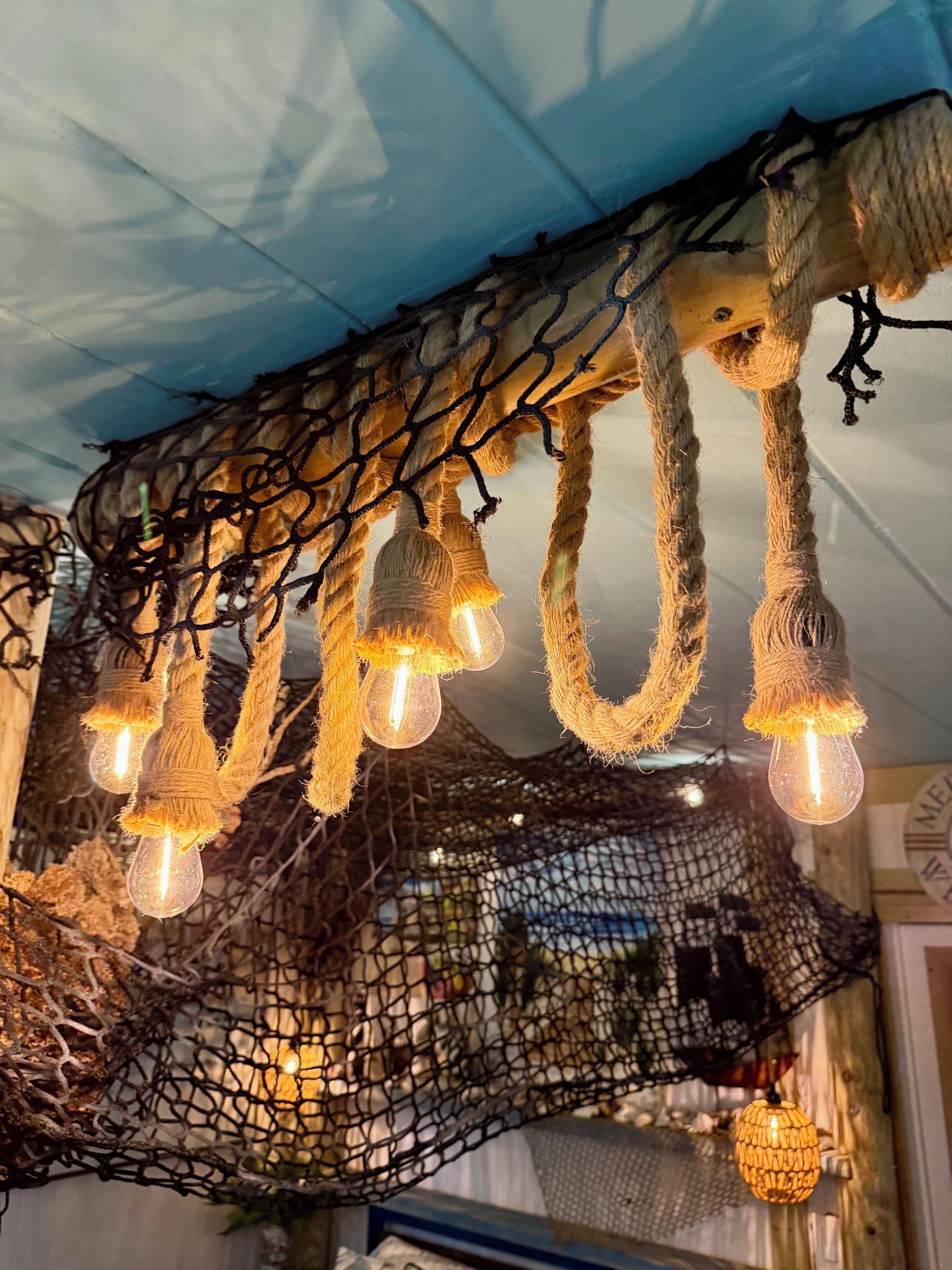 A ceiling with netted structures and hanging light fixtures.