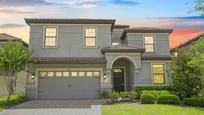 A two-story house with a garage, a front door, and a driveway. - 5 Star Villa With 9 Bedrooms, Orlando Villa 4227 (Davenport)