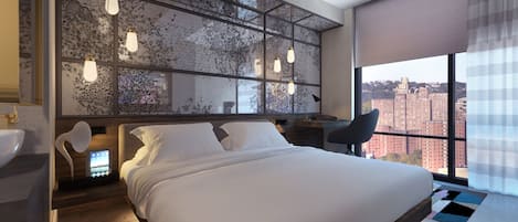 A modern hotel room with a large bed, a city view, a desk, and a bathroom.