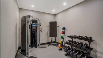 A gym with weightlifting equipment, including dumbbells and a squat rack.
