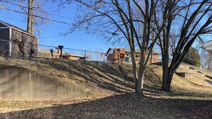 A residential area with a pond, a fenced yard, and houses in the background. - Cozy 2 bedroom + sleeping are close to Grant's Farm trail & 15 min. to downtown (St. Louis)