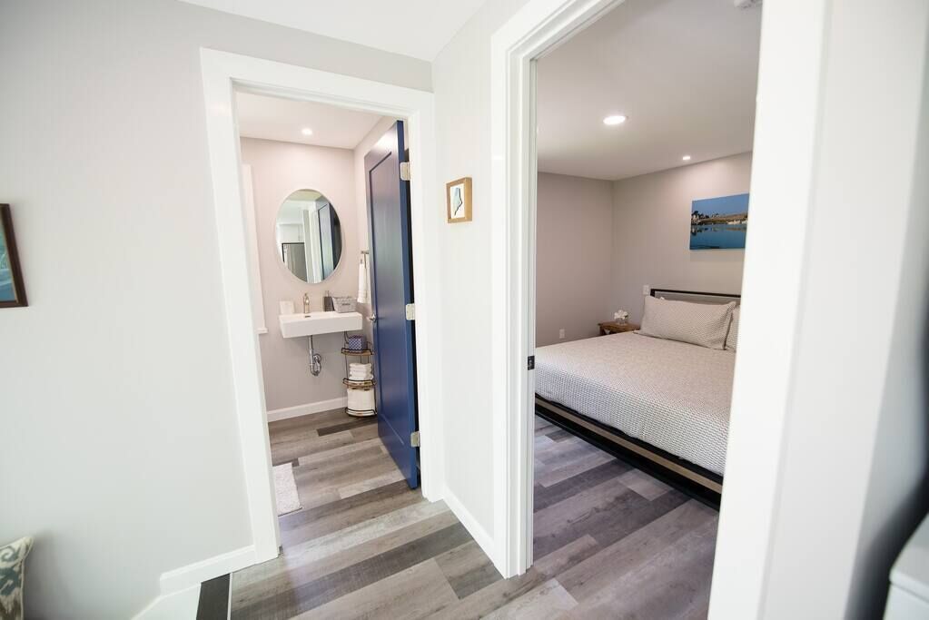 Une chambre à coucher avec un lit, une table de chevet et une étagère fixée au mur.