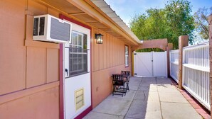 A covered patio with a table and chairs, an air conditioning unit, and a white fence. - Lakeland Vacation Rental: 38 Mi to Disney! (Lakeland)