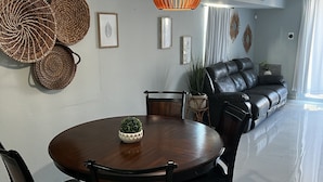 A dining area with a round table, chairs, and a hanging light fixture. - Eco-Luxury Villa with Pool, Beach Access, and 24 hour I uninterrupted power (Dorado)