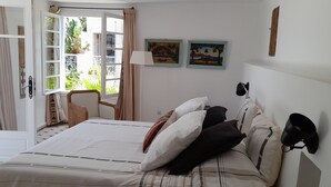 Ein Schlafzimmer mit Bett, Kissen, einer Lampe und einem Wandlautsprecher.