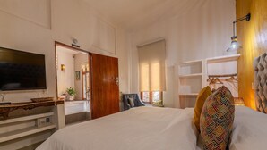 A hotel room with a large bed, a TV, a wooden door, and a view of the outside. - Casa Moraira (Cartagena)