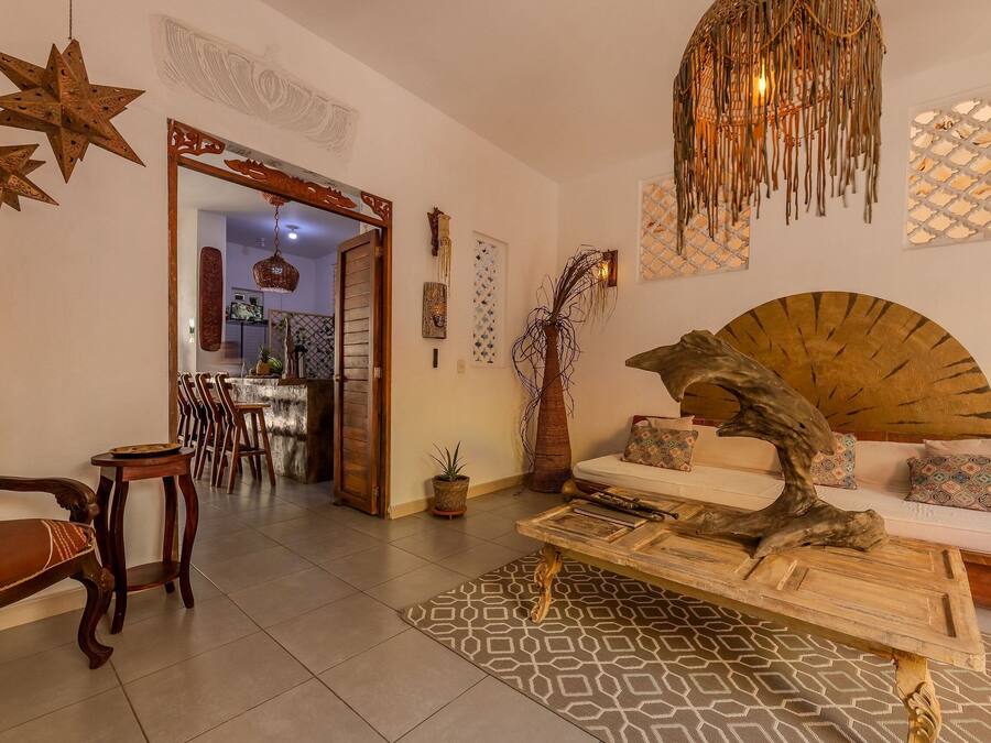 Un salón amplio con sofá, lámparas decorativas en forma de estrella y un ventilador de pared original.