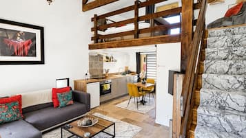 Um interior moderno com um quarto estilo loft, uma área de jantar e uma cozinha.