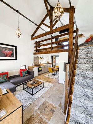 Un interior moderno con un dormitorio tipo loft, un comedor y una cocina.