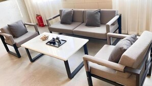A modern living room with a sofa, two armchairs, and a coffee table. - Greentree Inn Beijing Fangshan District Doudian Road Jinxin Yuan Express Hotel (Fangshan)